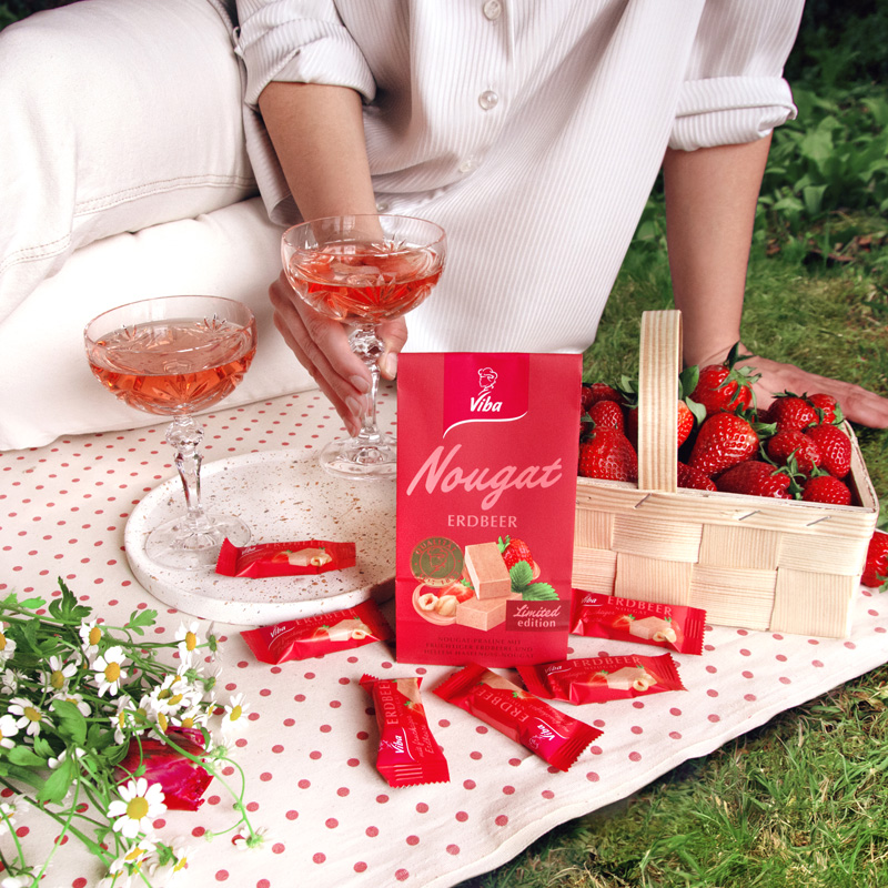 Viba Erdbeer Nougat Minis im Beutel beim Picknick mit Blumen, Prosecco im Glas und Erdbeeren im Körbchen