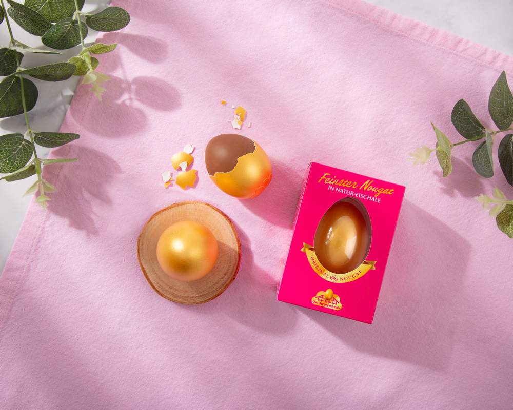 Viba Classic Nougat Osterei in Natureischale aufgeschlagen auf dem Frühlingstisch